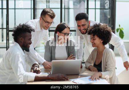 Employees working at computer together, discussing content Stock Photo