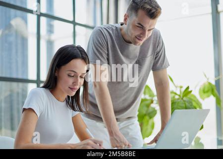 male ceo executive manager mentor giving consultation on financial operations to female colleague using laptop Stock Photo