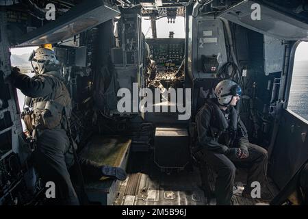 PACIFIC OCEAN (Feb. 18, 2022) U.S. Marines assigned to Marine Medium Tiltrotor Squadron (VMM) 165 (Reinforced), 11th Marine Expeditionary Unit (MEU), observe the ocean from a CH-53E Super Stallion during routine flight operations, Feb. 18. Marines and Sailors of the 11th MEU and Essex Amphibious Ready Group are underway conducting routine operations in U.S. 3rd Fleet. Stock Photo