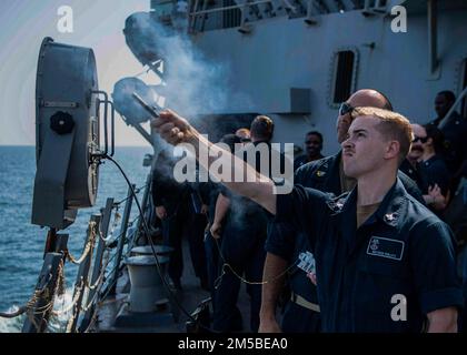 GULF OF OMAN (Feb. 21, 2022) Sonar Technician (Surface) 3rd Class Matthew Phillips, right, shoots a Mark 186 signaling kit’s L118 pencil flare during an anti-terrorism training evolution aboard guided-missile destroyer USS Gridley (DDG 101) in the Gulf of Oman, Feb. 21. Gridley is deployed to the U.S. 5th Fleet area of operations in support of naval operations to ensure maritime stability and security in the Central Region, connecting the Mediterranean and Pacific through the Western Indian Ocean and three strategic choke points. Stock Photo
