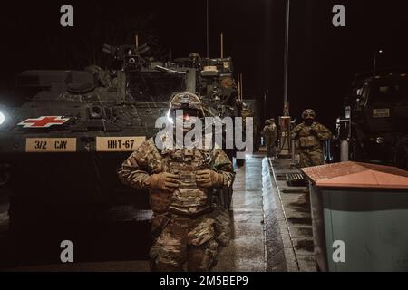 U.S. Army Soldiers assigned to 3rd Squadron, 2d Cavalry Regiment, refuel their vehicles while on a tactical road march on Feb. 21, 2022. 2CR conducts a winter tactical road march over 1500 km from Germany to Latvia to demonstrate its ability to deploy in an austere environment, foster multinational relationships, and increase interoperability with its NATO Allies and partners. Stock Photo