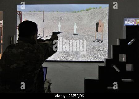 A U.S. Army Reserve Soldier double taps or shoots two quick shots at a simulated 'enemy' target in the Laser-Shot Mobile Marksmanship Training Simulator on Fort McCoy, Wis., Feb. 23, 2022. The simulator offers several shooting scenarios, including skill drills and judgmental training software. Stock Photo