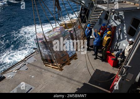ATLANTIC OCEAN (Feb. 23, 2022) Sailors aboard the Arleigh Burke-class guided-missile destroyer USS Roosevelt (DDG 80) receive pallets of stores during a replenishment-at-sea, Feb. 23, 2022. Roosevelt, forward-deployed to Rota, Spain, is on its third patrol in the U.S. Sixth Fleet area of operations in support of regional allies and partners and U.S. national security interests in Europe and Africa. Stock Photo