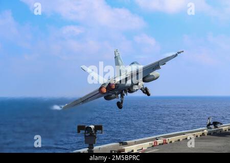 PHILIPPINE SEA (Feb. 24, 2022) An F/A-18E Super Hornet, assigned to the 'Vigilantes' of Strike Fighter Squadron (VFA) 151, launches from the flight deck of the Nimitz-class aircraft carrier USS Abraham Lincoln (CVN 72). Abraham Lincoln Strike Group is on a scheduled deployment in the U.S. 7th Fleet area of operations to enhance interoperability through alliances and partnerships while serving as a ready-response force in support of a free and open Indo-Pacific region. Stock Photo