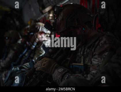 A U.S. Paratrooper assigned to 3rd Brigade Combat Team, 82nd Airborne Division checks the scope on his weapon while flying in a CH-47 Chinook helicopter alongside Polish soldiers from the 21st Rifle Brigade during a multi-national training event in Nowa Deba, Poland, Feb. 25, 2022. The focus of the 82nd Airborne Division's mission is to assure our Allies by providing a host of unique capabilities and conducting a wide range of missions that are scalable and tailorable to mission requirements. Stock Photo