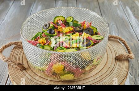 Salad with zucchini, oranges and salami of French gourmet cuisine, on wooden background Stock Photo