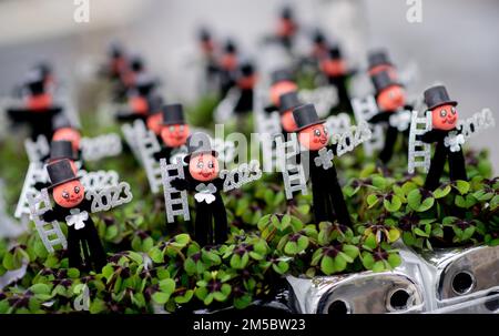 Weener, Germany. 21st Dec, 2022. Numerous clover plants with a small chimney sweep and the year '2023' stand on a transport cart in a horticultural business. The four-leaf clover, popular as a good luck charm, from a horticultural company in East Frisia is sold throughout Germany shortly before the end of the year. Credit: Hauke-Christian Dittrich/dpa/Alamy Live News Stock Photo