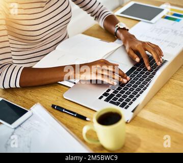 Working for a bright future. a unrecognizable persons hands typing on a laptop at home. Stock Photo