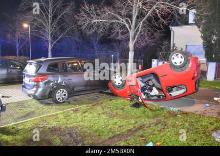 Walldorf, Germany. 27th Dec, 2022. A car involved in an accident lies on its roof. A 20-year-old female driver overturned her car in Walldorf in the Rhine-Neckar district. The driver and her three passengers were injured in the accident late Tuesday night, police said Wednesday. The car had unintentionally rolled away in the parking lot of a supermarket due to an operating error, crashed into a parked car and then overturned on a grass strip. There the car came to rest on its roof. Credit: Marvin Riess/Einsatz-Report24/dpa/Alamy Live News Stock Photo