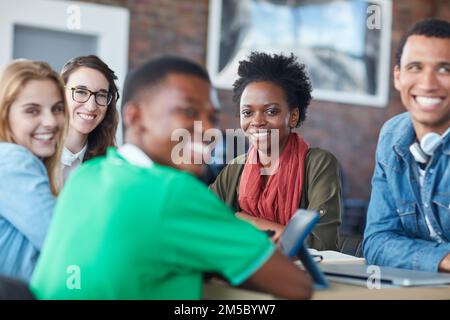 We crush group projects. Portrait of a group of university students working on a group project in class. Stock Photo