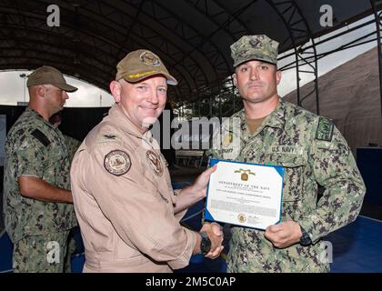 U.S. Navy Master-at-Arms 3rd Class Jonathan Blodgett, a Sailor from Peabody, Mass., is presented The Navy and Marine Corps Achievement Medal by Capt. David Faehnle, the commanding officer of Camp Lemonnier, Djibouti during a ceremony held on camp February 25th. Stock Photo
