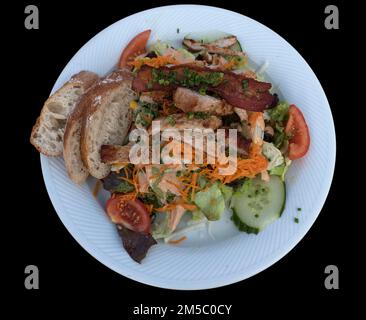 Salad plate with roasted turkey strips on a black background, Bavaria, Germany Stock Photo