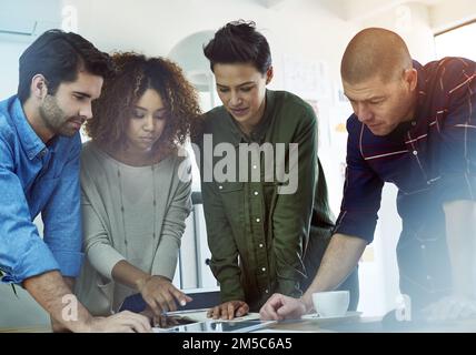 We all take part in decision making. a group of coworkers discussing something on a tablet. Stock Photo