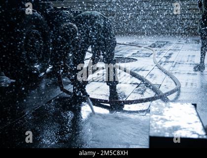A U.S. Marine with Combat Logistics Battalion (CLB) 31, sprays the well deck during a truck wash down aboard USS Green Bay, Gulf of Thailand, Feb. 28, 2022. The 31st MEU is operating aboard the ships of the America Amphibious Strike Group in the 7th fleet area of operations to enhance interoperability with allies and partners and serve as a ready response to defend peace and stability in the Indo–Pacific Region. Stock Photo