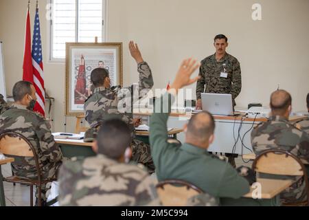 U.S. Marine Corps Staff Sgt. Donald Vautrinot, an explosive ordnance disposal (EOD) technician with 8th Engineer Support Battalion, 2nd Marine Logistics Group, answers questions from Royal Moroccan Armed Forces (FAR) soldiers in Morocco, Feb. 28, 2022. Marines, Sailors, and members of the Utah National Guard are participating in Humanitarian Mine Action, Explosive Ordnance Disposal (EOD) Morocco 2022 where U.S. EOD technicians are supervising level three EOD validation of Royal Moroccan Armed Forces soldiers to continue efforts to create an EOD capability inside the FAR. Stock Photo