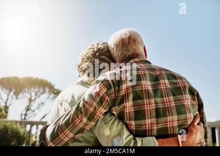 Life looks great from here on out. Rearview shot of a senior couple embracing outside on the balcony. Stock Photo