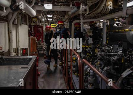 220225-N-XB010-1001 PACIFIC OCEAN (Feb. 25, 2022) Sailors assigned to USS New Orleans (LPD 18) overhaul an engine space during a fire drill. New Orleans, part of the America Amphibious Ready Group, along with the 31st Marine Expeditionary Unit, is operating in the U.S. 7th Fleet area of responsibility to enhance interoperability with allies and partners and serve as a ready response force to defend peace and stability in the Indo-Pacific region. Stock Photo