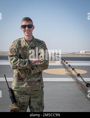 Senior Airman Kenny Jenkins, an electrical power production journeyman assigned to the 380th Expeditionary Civil Engineer Squadron’s barrier maintenance team, Al Dhafra Air Base, United Arab Emirates, stands next to one of two mobile Barrier Arresting Kits on the runway used by U.S. forces here. The mobile aircraft arresting system is a 19,500-pound mechanical barrier capable of rapidly decelerating a landing aircraft using a cable situated across the runway capable of safely catching an aircraft weighing as much as 80,000 pounds, calculated by weight and speed. Stock Photo