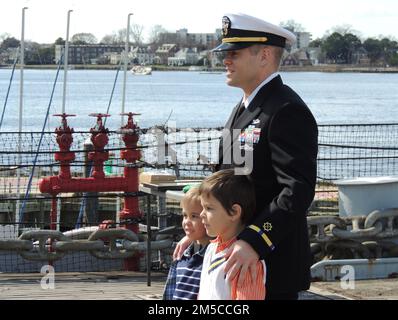 OSCS Chris Harold, assigned to USS John C. Stennis (CVN-74), stands with his sons Dominic and Alexander Harold as he is commissioned as a Chief Warrant Officer 2 aboard the Battleship Wisconsin in Downtown Norfolk, Virginia. The commissioning ceremony was hosted by the Hampton Roads Naval Museum, located next door to the Battleship. Stock Photo