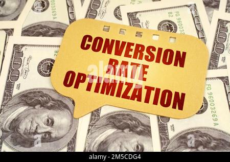 Business concept. On the dollars is a sign with the inscription - conversion rate optimization Stock Photo
