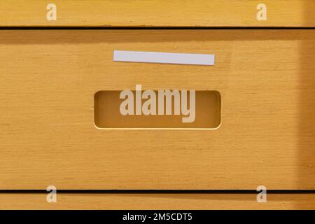 Wooden drawer with blank white label Stock Photo