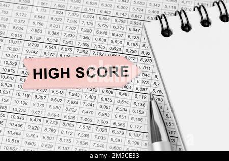 Business concept. On the table among the reports is a notebook, a pen with an arrow with the inscription - High Score Stock Photo