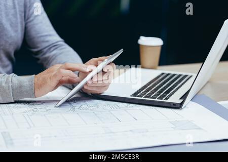 Close-up photo of hands of male designer architect working with tablet computer inside modern office. Stock Photo