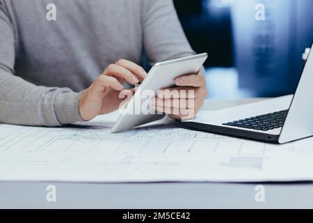 Close-up photo of hands of male designer architect working with tablet computer inside modern office. Stock Photo