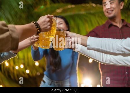 Group of happy friends drinking and toasting beer at a party backyard Stock Photo