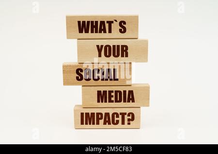 Business concept. On a white surface are wooden blocks with the inscription - What is Your Social Media Impact Stock Photo