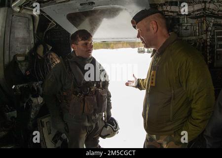 A U.S. Marine crew chief on a CH-53 Super Stallion (left), speaks with Norwegian Army Lt. Gen. Yngve Odlo about the crew's standard operating procedures when performing a Bandvagon 206 lift prior to Cold Response 22 in Bardufoss , Norway, Feb. 28, 2022. Exercise Cold Response '22 is a biennial Norwegian national readiness and defense exercise that takes place across Norway, with participation from each of its military services, as well as from 26 additional North Atlantic Treaty Organization (NATO) allied nations and regional partners.