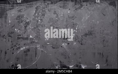 Front view of a messy, dirty and weathered plywood wall with stains from graffiti removal. Abstract full frame textured background in black and white. Stock Photo