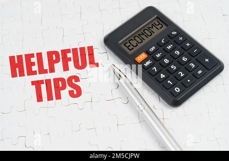 Business concept. On the puzzles lies a calculator and a pen, next to the inscription - Helpful Tips Stock Photo