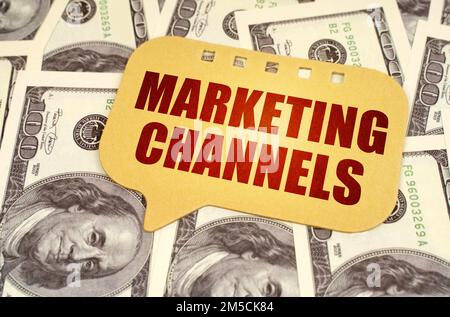 Business concept. On the dollars is a sign with the inscription - marketing channels Stock Photo