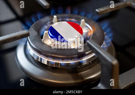 Gas import and export concept. A burning gas burner of a home stove, in the middle of which a flag is depicted - France Stock Photo