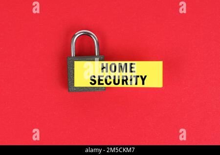 Business and security concept. On the red surface there is a lock with a sticker with the inscription - home security Stock Photo