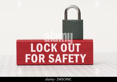 Business and security concept. On the reports there is a red block with the inscription - lock out for safety and a lock. Stock Photo