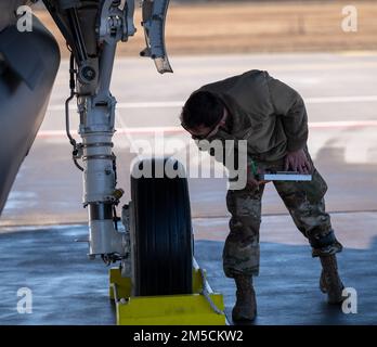 U.S. Air Force Tech. Sgt. Joshua Eades, 495th Aircraft Maintenance Squadron F-35 flight line expeditor, inspects an F-35 Lightning II aircraft tire for damage after a flying operation at Siauliai Air Base, Lithuania, March 2, 2022. Maintainers supported flying operations to ensure the fifth generation aircraft, assigned to the 48th Fighter Wing, Royal Air Force Lakenheath, England, was ready 24/7 to support NATO’s enhanced air policing mission in the Baltic region. Stock Photo