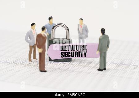 The concept of security in business. There are figures of people on business reports, a padlock with a sticker on which it is written - Network securi Stock Photo