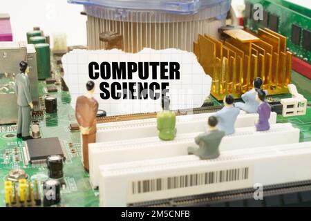 Technology and computer concept. On the motherboard there are figures of people and torn paper with the inscription - Computer Science Stock Photo