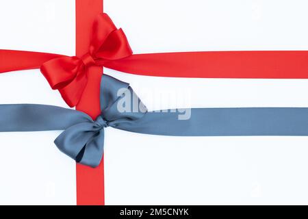 Satin ribbon bows for gift pack in gray and red colors, isolated on white background. Background with ribbon knot on white background. Stock Photo