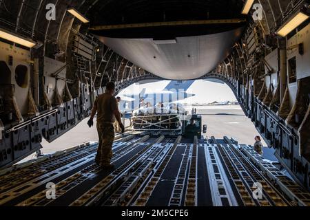 Airmen from the 535th Airlift Squadron work alongside the 647th Logistics Readiness Squadron combat mobility flight to load cargo from a Tunner 60K aircraft cargo loader/transporter onto a C-17 Globemaster III during Exercise TROPIC FURY at Joint Base Pearl Harbor-Hickam, Hawaii, March 2, 2022. The Tunner 60k can hold up to 60,000 lbs of cargo and allows Airmen to safely and effectively transport and load cargo onto aircraft. Stock Photo