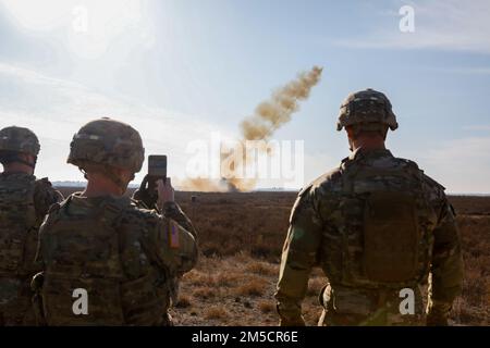 U.S. Soldiers assigned to the 1st Brigade Engineer Battalion, 1st Armored Brigade Combat Team, 1st Infantry Division record an inert M58 Mine Clearing Line Charge at Karliki, Poland, March 2, 2022. A MICLIC is a rocket projected explosive line charge that can clear mines in an eight by ten meters patch of land to pass through dangerous areas safely. Stock Photo