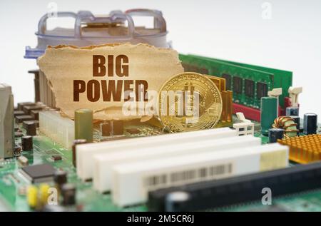 Crypto - business concept. On the motherboard lies a bitcoin coin and a cardboard sign with the inscription - big power Stock Photo