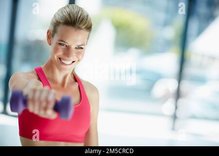 Exercising with a smile. an attractive young woman working out with dumbbells. Stock Photo