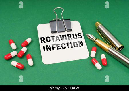 Medical concept. On the green surface of the tablet, a pen and a notepad with the inscription - Rotavirus infection Stock Photo