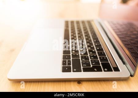 Modern laptop on a wooden table. Computer keyboard closeup Stock Photo