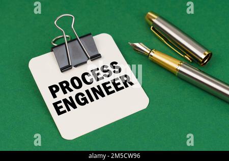 Business and industry concept. On a green surface, a pen and a sheet of paper with the inscription - Process Engineer Stock Photo