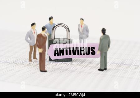The concept of security in business. There are figures of people on business reports, a padlock with a sticker on which it is written - Antivirus Stock Photo