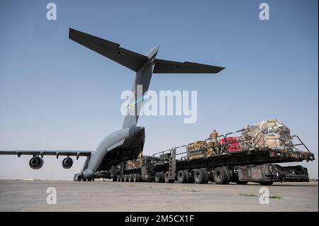 U.S. Air Force aircrew members assigned to the 816th Expeditionary Airlift Squadron offload cargo from a U.S. Air Force C-17 Globemaster III at Ali Al Salem Air Base, Kuwait, March 2, 2022. The C-17 Globemaster III is capable of rapid strategic delivery of troops and cargo directly to main or forward operating bases in the U.S. Central Command area of responsibility. Stock Photo